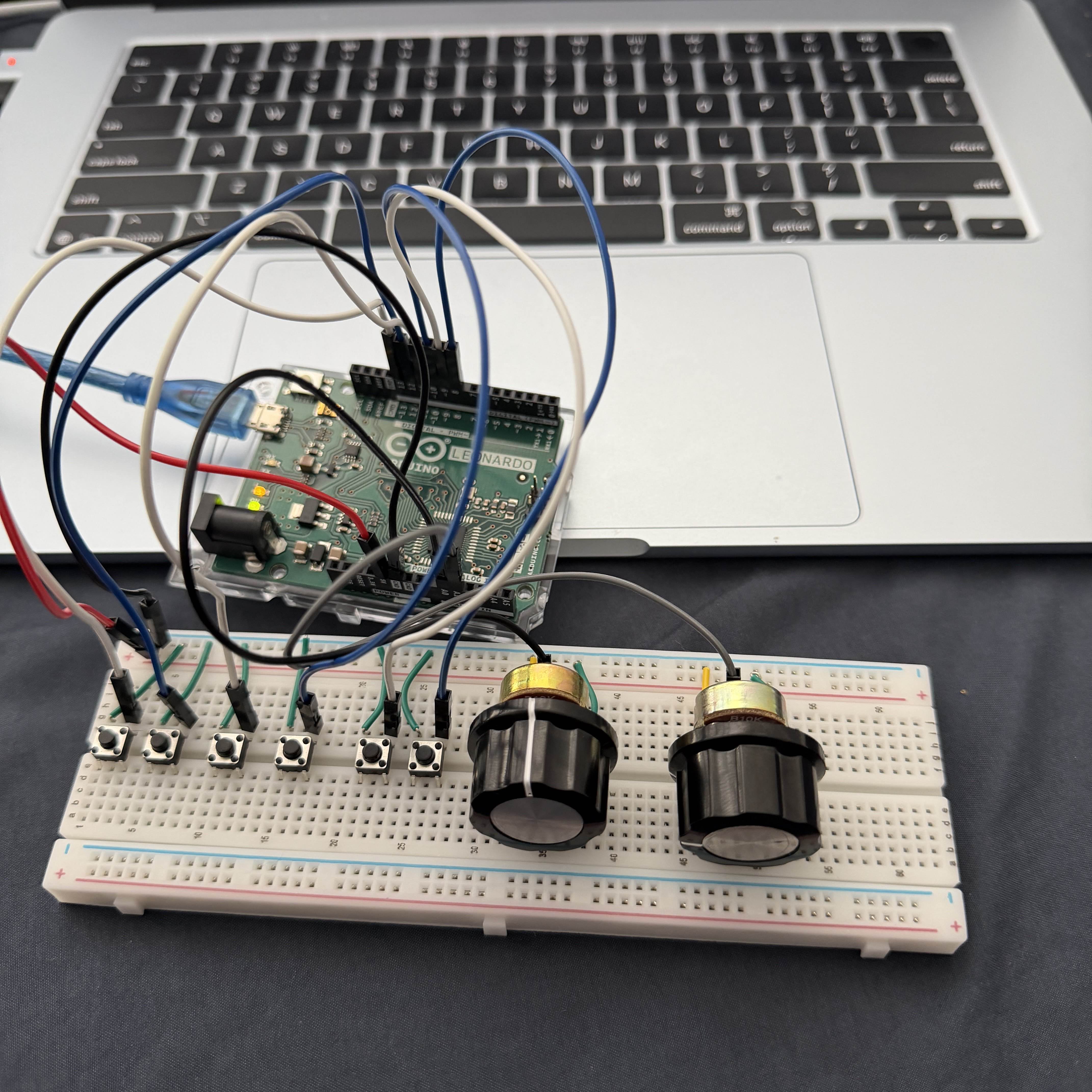 Breadboard and Arduino setup with multiple buttons and potentiometers connected, representing a more complete version of the controller.