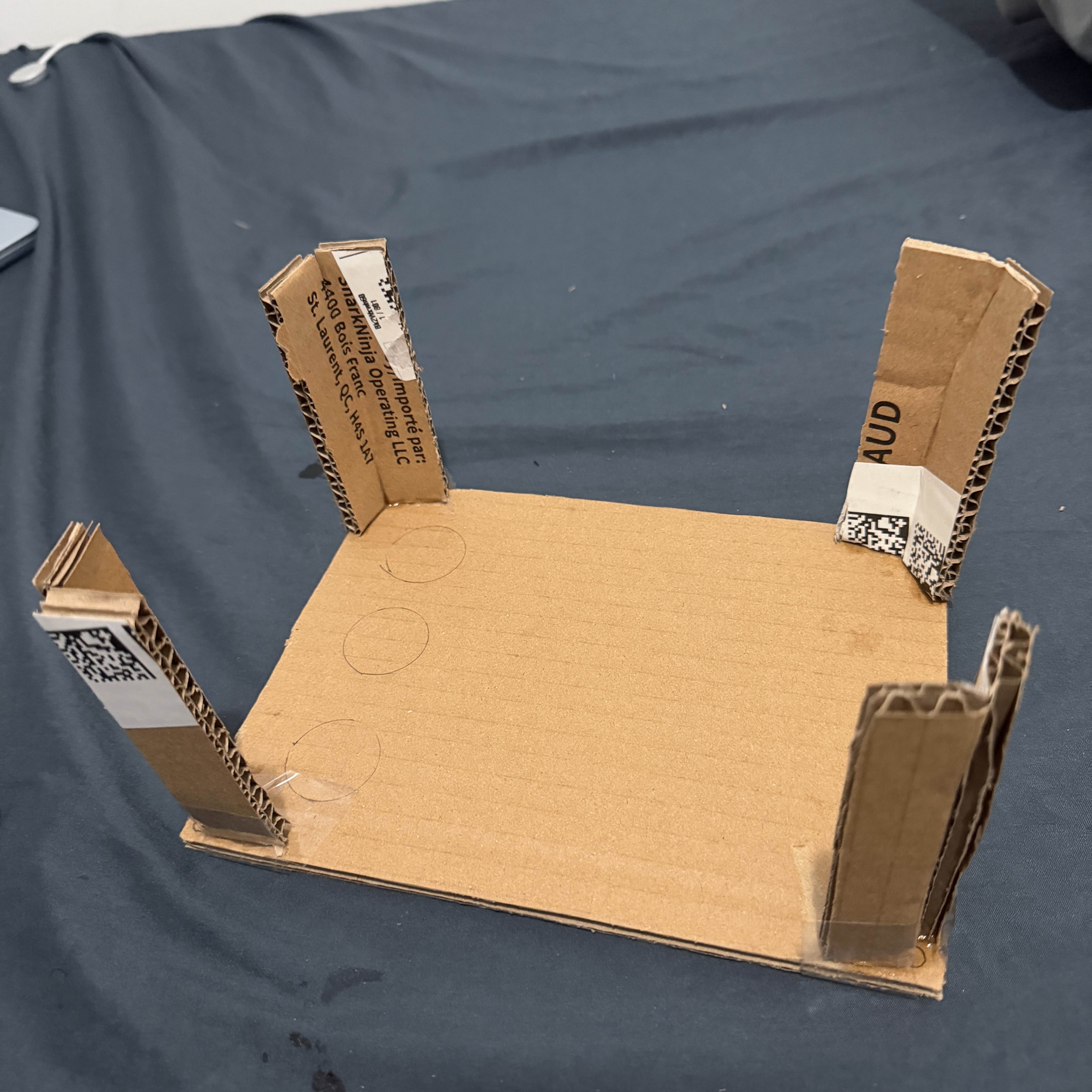 Initial cardboard frame showing the basic structure and height of the controller with four standing support legs.